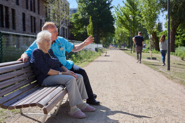 Bewoner met verzorger op het bankje
